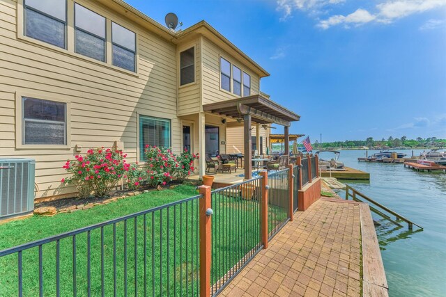 343 Old Aqua Lndg E, Conroe, TX 77356 - dock area featuring central air condition unit, fence, a patio, a water view, and a yard