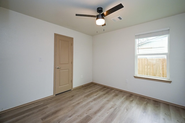 empty room with visible vents, ceiling fan, and light wood-type flooring