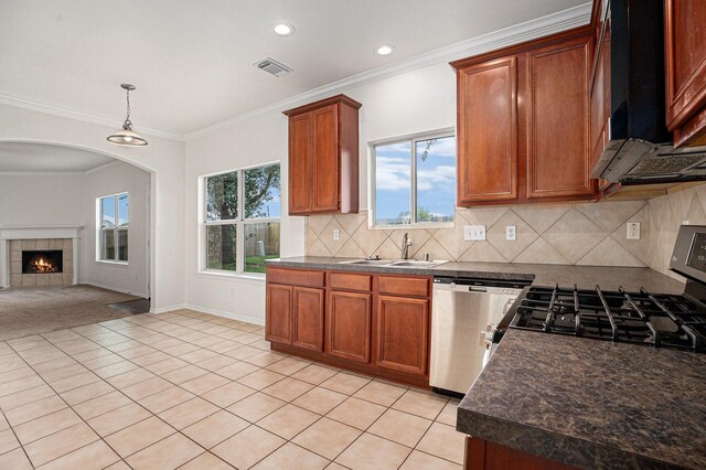 2522 Barton Springs St, League City, TX 77573 - kitchen featuring appliances with stainless steel finishes, a sink, dark countertops, light tile patterned floors, and brown cabinetry