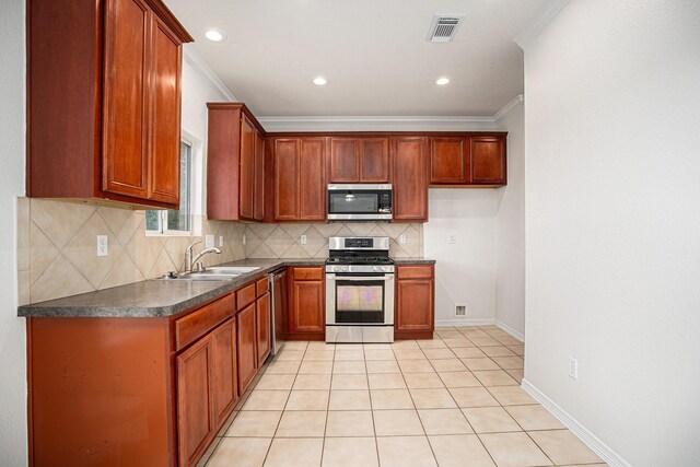 2522 Barton Springs St, League City, TX 77573 - kitchen featuring stainless steel appliances, a sink, dark countertops, backsplash, and crown molding