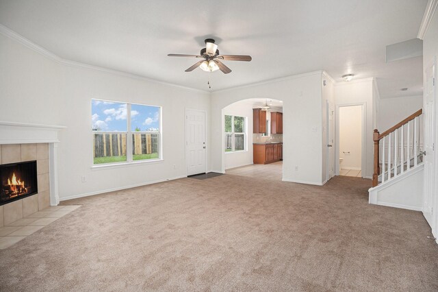 2522 Barton Springs St, League City, TX 77573 - unfurnished living room with carpet floors, ceiling fan, a tiled fireplace, arched walkways, and ornamental molding