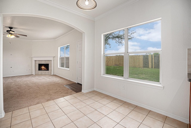2522 Barton Springs St, League City, TX 77573 - unfurnished living room with light carpet, a ceiling fan, crown molding, arched walkways, and light tile patterned flooring