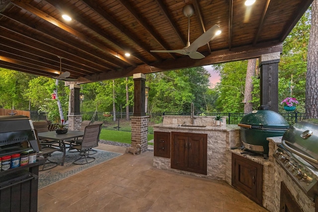 view of patio with a sink, area for grilling, a fenced backyard, and outdoor dining area