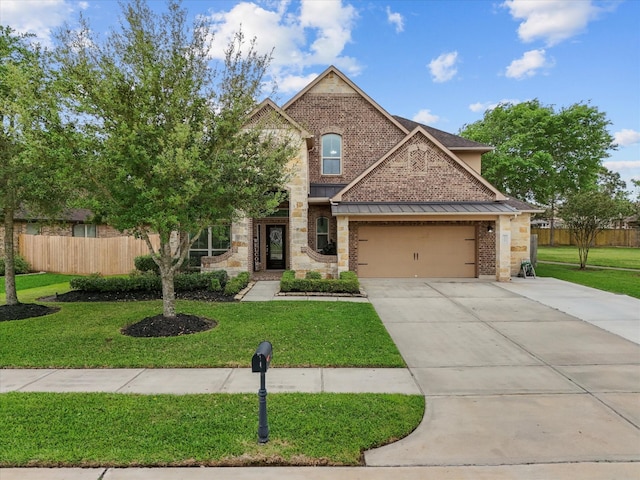 view of front facade with a front yard, fence, brick siding, and concrete driveway