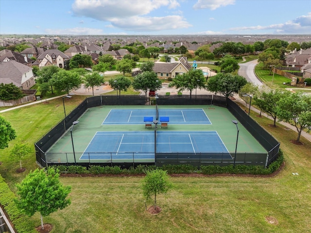 view of tennis court with a residential view and fence