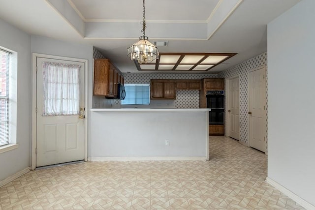 16918 Ascot Meadow Dr, Sugar Land, TX 77479 - kitchen featuring brown cabinets, an inviting chandelier, a peninsula, and wallpapered walls
