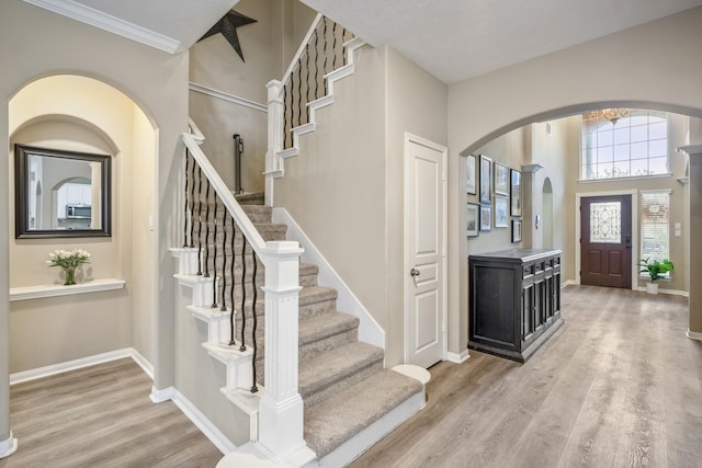 11826 Thoreau Dr, Montgomery, TX 77356 - foyer featuring crown molding, arched walkways, stairway, baseboards, and light wood-style floors