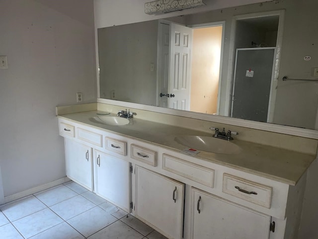 full bath featuring double vanity, a sink, tile patterned floors, and a shower stall