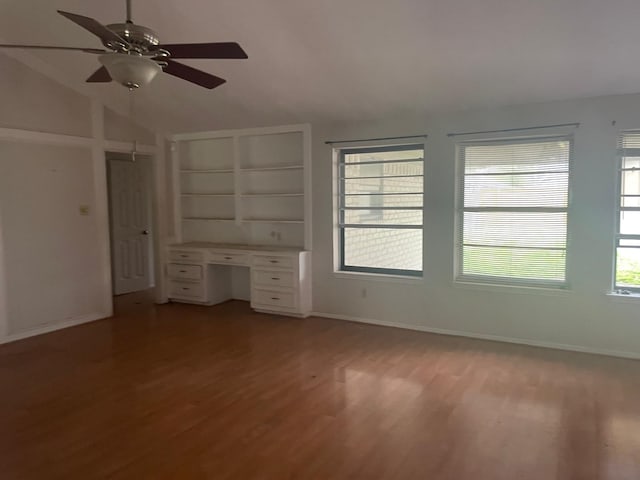 interior space featuring baseboards, lofted ceiling, light wood-style floors, and a ceiling fan