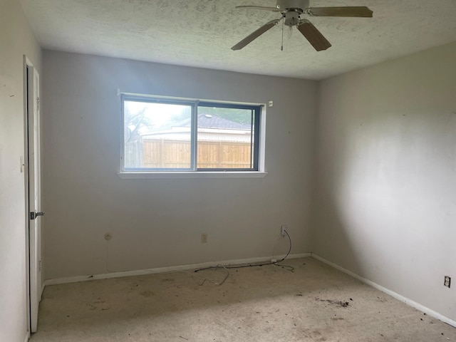 spare room featuring baseboards, ceiling fan, and a textured ceiling