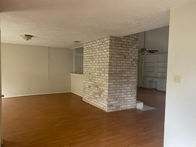 unfurnished room with a textured ceiling, wood finished floors, and ceiling fan