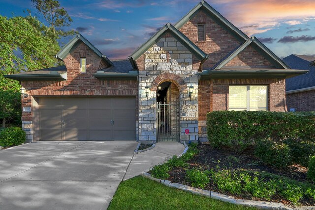 3507 Manor Lake Ln, Spring, TX 77386 - view of front of home featuring a garage, brick siding, stone siding, and concrete driveway