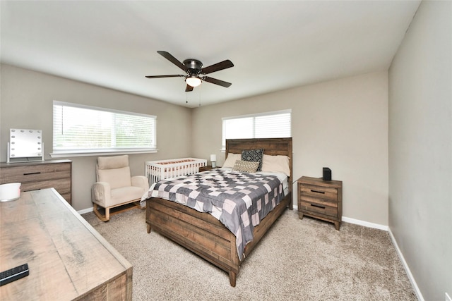 carpeted bedroom featuring baseboards and ceiling fan