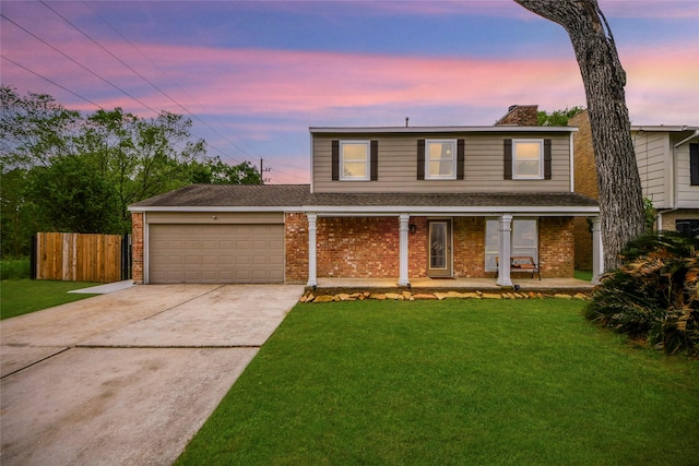 traditional-style home featuring brick siding, an attached garage, a lawn, and driveway