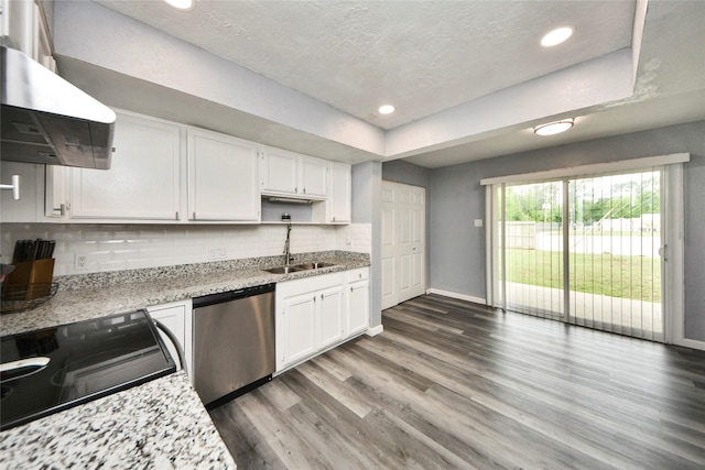 kitchen with wall chimney exhaust hood, wood finished floors, dishwasher, baseboards, and white cabinetry