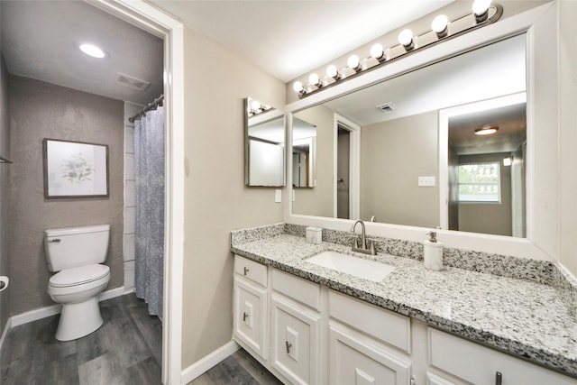 full bathroom with vanity, toilet, wood finished floors, and visible vents