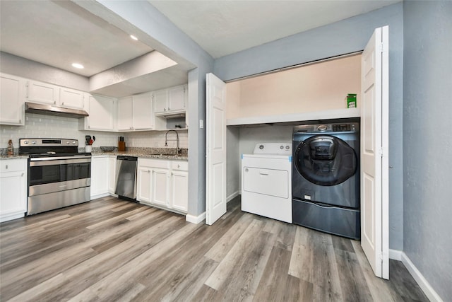 kitchen featuring washer / clothes dryer, under cabinet range hood, appliances with stainless steel finishes, and white cabinetry