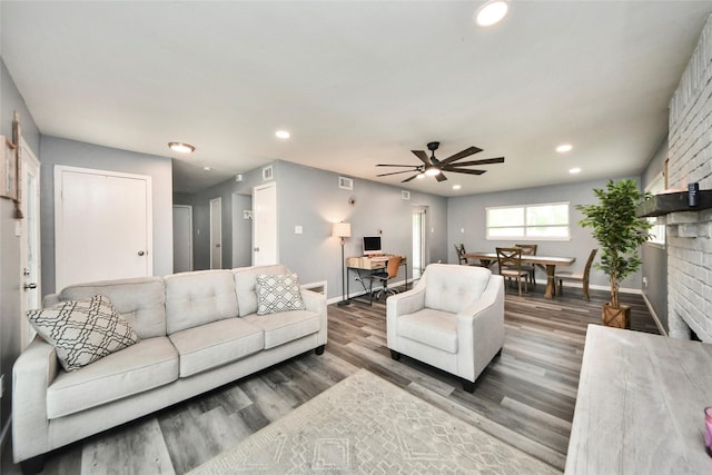 living area featuring baseboards, a ceiling fan, wood finished floors, and visible vents