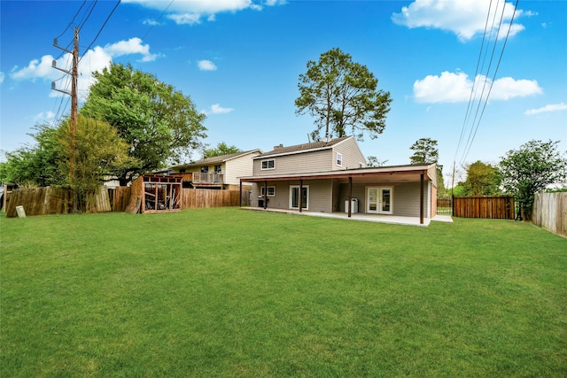back of house with a yard, a fenced backyard, and a patio area