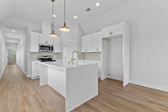 416 13th St, San Leon, TX 77539 - kitchen featuring appliances with stainless steel finishes, vaulted ceiling, light countertops, white cabinetry, and recessed lighting