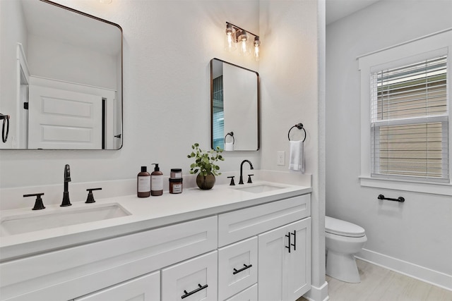416 13th St, San Leon, TX 77539 - full bathroom featuring toilet, baseboards, and double vanity