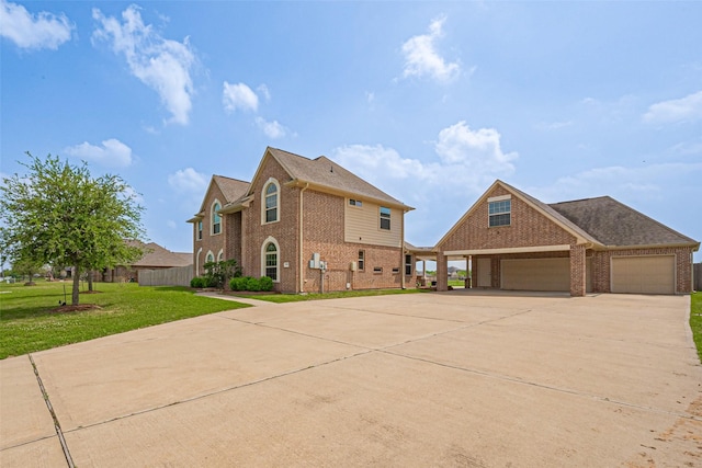 exterior space featuring brick siding, driveway, an attached garage, and a lawn