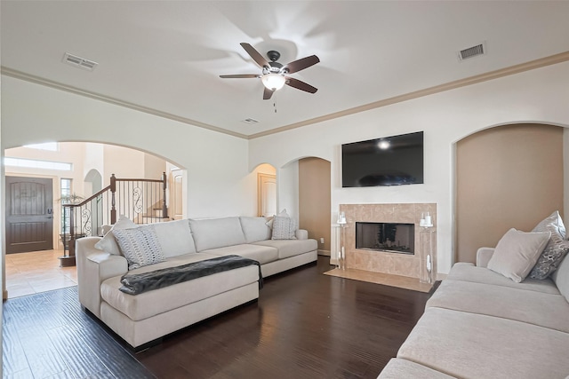 living room with a ceiling fan, arched walkways, wood finished floors, and visible vents
