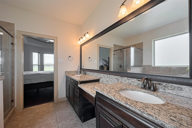 ensuite bathroom featuring ensuite bathroom, a sink, a stall shower, and tile patterned flooring