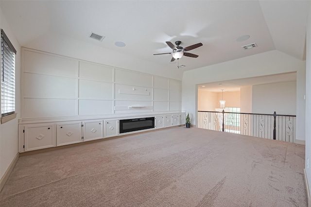 unfurnished living room featuring visible vents, ceiling fan, carpet, and vaulted ceiling
