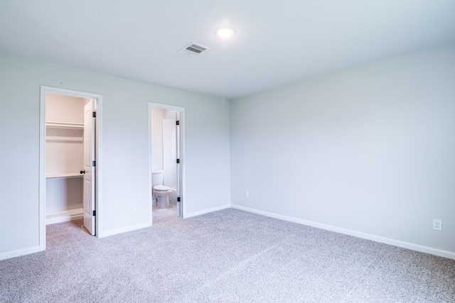 6714 Scott St, Liverpool, TX 77577 - unfurnished bedroom featuring a closet, baseboards, carpet floors, a walk in closet, and visible vents
