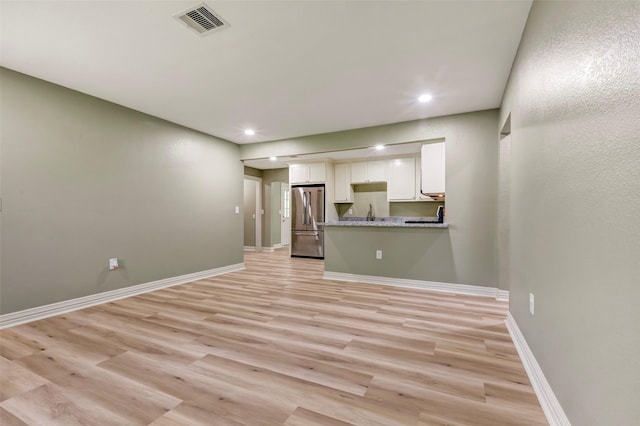 unfurnished living room with baseboards, visible vents, recessed lighting, and light wood-style floors