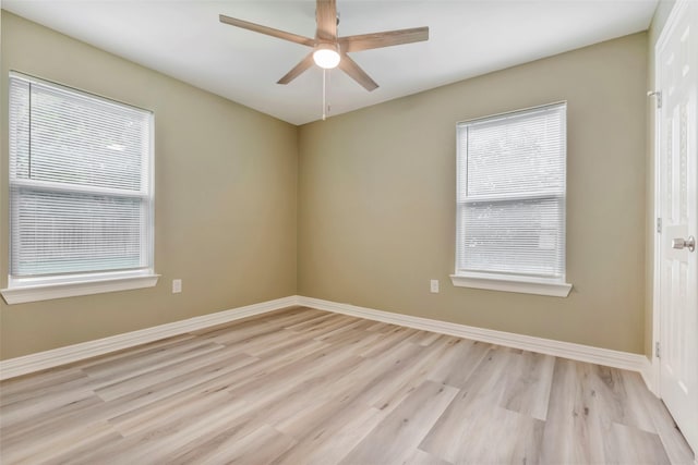 spare room with light wood finished floors, baseboards, and a ceiling fan