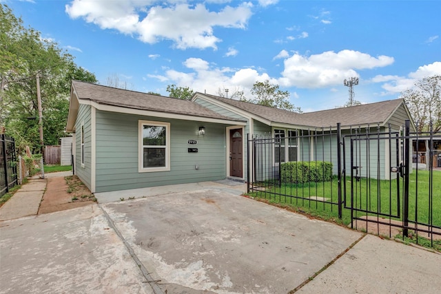 view of front of house featuring a gate, a fenced front yard, a shingled roof, and a front yard