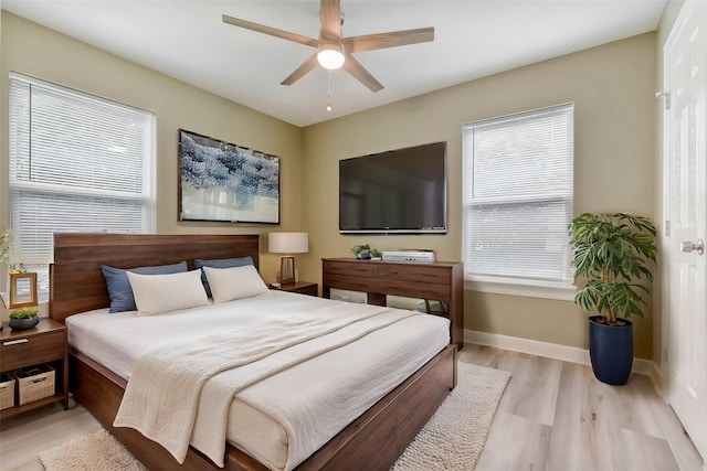 bedroom with baseboards, ceiling fan, and light wood-type flooring