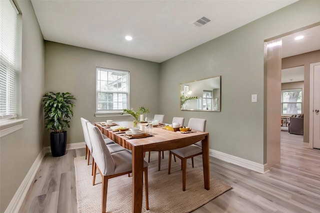 dining area with plenty of natural light, baseboards, and light wood finished floors