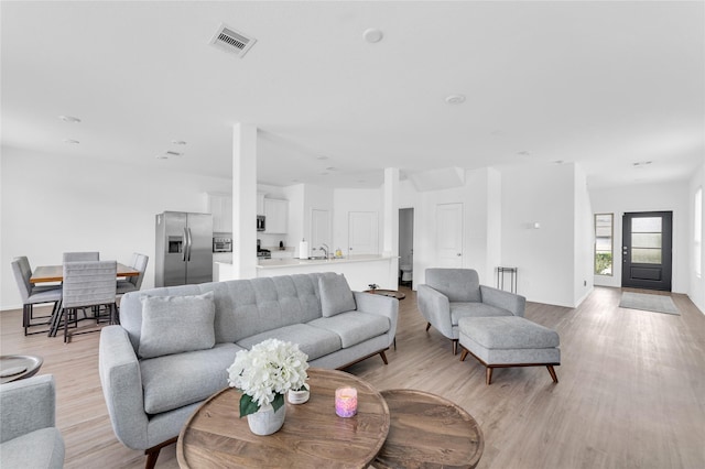 living area with visible vents and light wood-style flooring