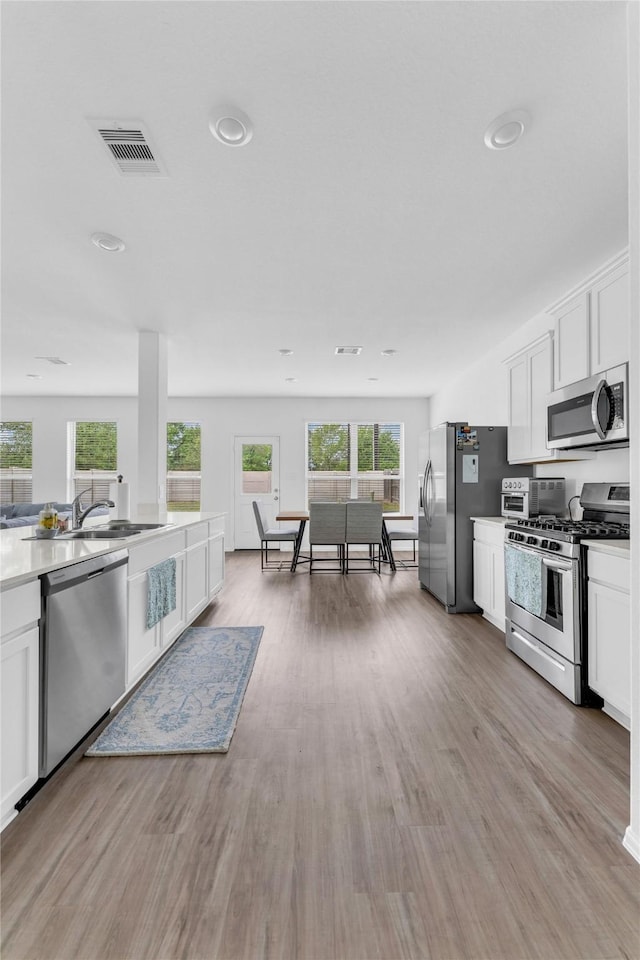 kitchen featuring visible vents, light wood finished floors, stainless steel appliances, and a healthy amount of sunlight