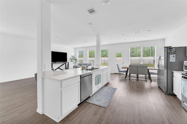 kitchen with dishwasher, visible vents, dark wood-style floors, and a sink