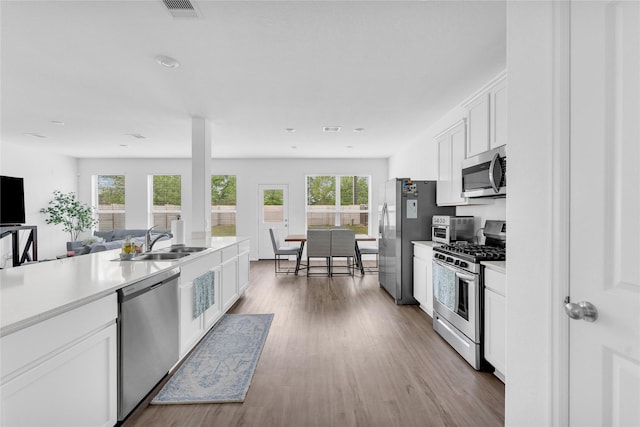 kitchen featuring white cabinets, visible vents, appliances with stainless steel finishes, and a sink