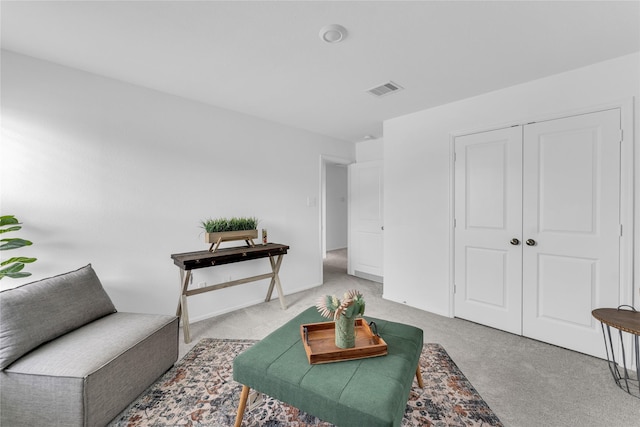 sitting room with visible vents and light colored carpet