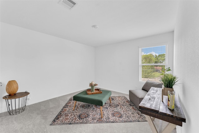 living area with visible vents and carpet