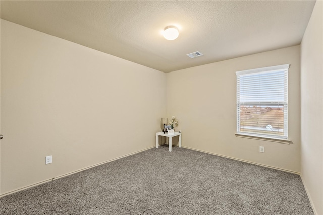 unfurnished room with carpet, a textured ceiling, and visible vents