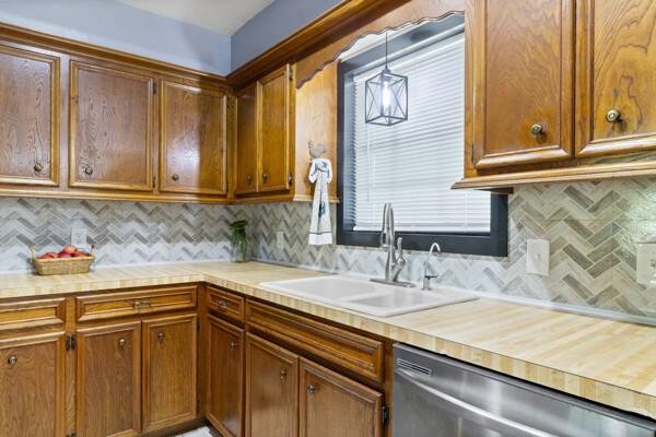1760 County Road 965, Alvin, TX 77511 - kitchen with stainless steel dishwasher, a sink, light countertops, and decorative backsplash