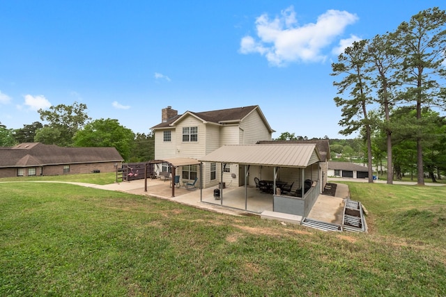 back of property with a lawn, a chimney, and a patio