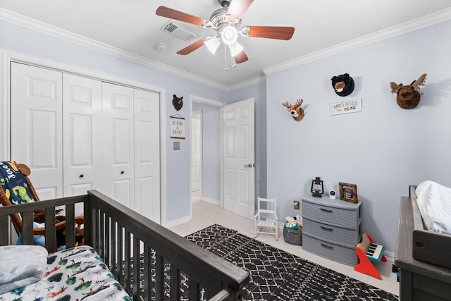 bedroom with crown molding, baseboards, ceiling fan, visible vents, and a closet