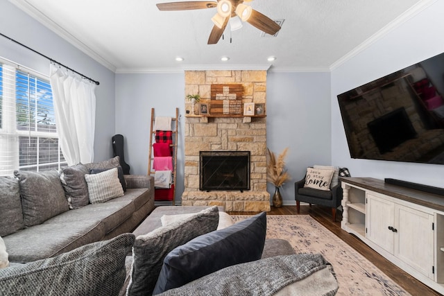 living area featuring wood finished floors, crown molding, a fireplace, and ceiling fan