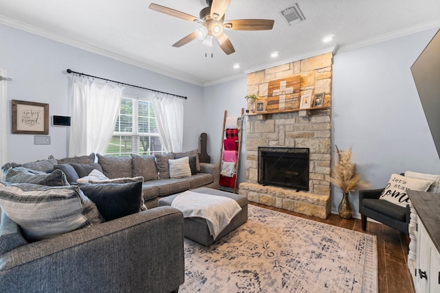 living area with ornamental molding, visible vents, a ceiling fan, and wood finished floors