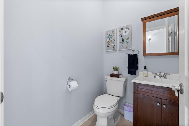 half bathroom featuring tile patterned floors, toilet, baseboards, and vanity