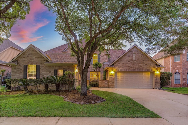 traditional home featuring brick siding, driveway, and a lawn