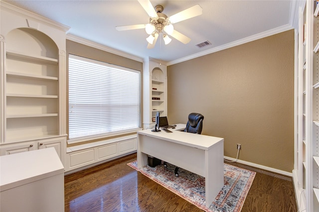 office with visible vents, built in shelves, a ceiling fan, crown molding, and dark wood-type flooring